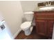 Bathroom featuring a granite-topped vanity, toilet, and wood flooring for a cohesive and functional design at 7753 W Plymouth S Pl, Littleton, CO 80128
