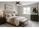 Comfortable bedroom with a tufted headboard, bench, and ample natural light from the window at 7753 W Plymouth S Pl, Littleton, CO 80128