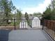 Relaxing deck overlooking the backyard, featuring sturdy railings and a view of storage sheds at 7753 W Plymouth S Pl, Littleton, CO 80128