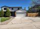 Traditional two-story home with a brick-accented garage and a large concrete driveway at 7753 W Plymouth S Pl, Littleton, CO 80128
