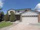 Charming two-story home featuring a well-maintained lawn, mature trees, and a convenient two-car garage at 7753 W Plymouth S Pl, Littleton, CO 80128