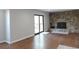 Bright living room featuring a stone fireplace, hardwood floors, and patio access at 7753 W Plymouth S Pl, Littleton, CO 80128