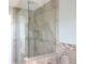 Bathroom shower featuring neutral toned tile, a glass partition and multiple shower heads at 7753 W Plymouth S Pl, Littleton, CO 80128