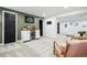 Open basement layout with bar, seating and workout space with neutral carpeting at 6885 E Briarwood Cir, Centennial, CO 80112