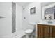Bathroom featuring a sleek, modern shower with white and mosaic tile, vanity and toilet at 6885 E Briarwood Cir, Centennial, CO 80112