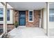Charming brick front porch entry with a security door and 'Welcome' sign at 6885 E Briarwood Cir, Centennial, CO 80112