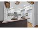 Well-lit kitchen with granite counters, white cabinets, and stainless appliances, offering a practical cooking space at 6885 E Briarwood Cir, Centennial, CO 80112