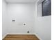 Unfinished laundry room with utility hookups, window and laminate flooring at 6885 E Briarwood Cir, Centennial, CO 80112