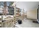 Relaxing covered patio with wood fence, concrete floor, and views of the snowy neighborhood at 6885 E Briarwood Cir, Centennial, CO 80112
