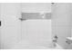 Bright white tiled shower-tub combo with chrome fixtures at 6885 E Briarwood Cir, Centennial, CO 80112
