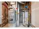 Utility room featuring modern furnace, water heater, and essential home systems at 6885 E Briarwood Cir, Centennial, CO 80112