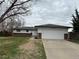 Ranch-style home featuring a two-car garage and manicured front lawn at 3038 S Xenia Ct, Denver, CO 80231