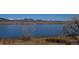 Scenic lake view overlooking the mountain range, with grassy foreground and clear skies at 8450 Everett Way # D, Arvada, CO 80005