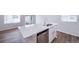 The kitchen island has a stainless steel dishwasher, a quartz countertop, and ample space and natural light at 46561 Avery Ln, Bennett, CO 80102