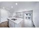 This kitchen island features a stainless steel dishwasher, quartz countertops, and opens up into the living room at 46561 Avery Ln, Bennett, CO 80102