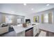 The kitchen island boasts a stainless steel dishwasher, a quartz countertop, and views of the living room at 46561 Avery Ln, Bennett, CO 80102