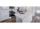 This kitchen has a quartz countertop island, stainless steel appliances, and a subway tile backsplash at 46561 Avery Ln, Bennett, CO 80102