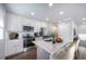 Bright kitchen boasts stainless steel appliances, modern white cabinets, and a quartz countertop island with seating at 46561 Avery Ln, Bennett, CO 80102
