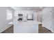 This kitchen has an island with quartz countertops, stainless steel appliances, and white cabinets at 46561 Avery Ln, Bennett, CO 80102