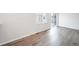 Bright living room with modern wood floors, neutral walls, and a sliding glass door at 46561 Avery Ln, Bennett, CO 80102