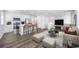 Open concept living and kitchen area with kitchen island, bar seating, and lots of natural light at 46561 Avery Ln, Bennett, CO 80102
