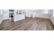 Open concept living room boasts modern wood floors flowing into a well-equipped kitchen with stainless appliances at 46561 Avery Ln, Bennett, CO 80102