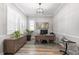 Home office featuring wood floors, white walls and trim, modern light fixture, and large window at 10976 Lewiston St, Commerce City, CO 80022
