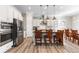 Eat-in kitchen featuring stainless steel appliances, white cabinets and hardwood floors at 10976 Lewiston St, Commerce City, CO 80022