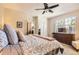 Bright bedroom featuring a ceiling fan, large window, and an ensuite bathroom for comfortable living at 601 Clarendon Loop, Castle Pines, CO 80108