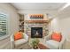 Basement sitting area with a stone fireplace and comfortable armchairs at 26175 E Fair Pl, Centennial, CO 80016