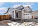 Charming home featuring a covered entry, attached two-car garage, and professionally landscaped front yard at 9376 Yampa Ct, Commerce City, CO 80022