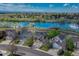 A scenic aerial view showcases homes in a waterside community with lush landscaping and mature trees, reflecting the blue sky at 18885 E Union Dr, Aurora, CO 80015