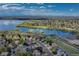 A panoramic aerial view captures homes nestled alongside a serene lake, surrounded by lush greenery and distant mountain views at 18885 E Union Dr, Aurora, CO 80015