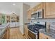 Modern kitchen with stainless steel appliances, granite countertops, and a view of the living room at 18885 E Union Dr, Aurora, CO 80015