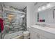 Modern bathroom featuring a stylish shower with new tiling, a vanity, and updated fixtures at 3332 S Ammons St # 103, Lakewood, CO 80227