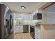Modern kitchen featuring white cabinets, stainless steel appliances, and a decorative backsplash at 3332 S Ammons St # 103, Lakewood, CO 80227