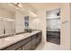 Bathroom with dual sinks, vanity, and view into the bedroom and shower at 7833 Bandit Dr, Castle Rock, CO 80108