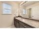 Bathroom with stylish vanity, granite counters, large mirror, and ample natural light streaming through the window at 7833 Bandit Dr, Castle Rock, CO 80108