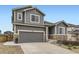 Beautiful home with gray siding, stone accents, and a well-kept lawn and driveway at 7833 Bandit Dr, Castle Rock, CO 80108