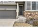 Inviting front entrance with a wreath, stone accents, and well-maintained landscaping at 7833 Bandit Dr, Castle Rock, CO 80108