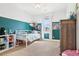 Fun bedroom painted with a dark teal accent wall, a large window, and a ceiling fan at 311 Portmeirion Ln, Castle Rock, CO 80104