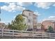 Rear view of a multi-story home with a fenced yard, deck and mature evergreens at 311 Portmeirion Ln, Castle Rock, CO 80104