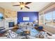 Cozy living room with stone fireplace, plush seating, and natural light from large windows at 311 Portmeirion Ln, Castle Rock, CO 80104