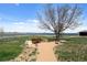 Well-kept common area with a sand path, seating, and views of the tranquil lake at 5425 County Road 32 # 14, Mead, CO 80504