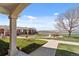 Inviting apartment complex entrance with green space, a mature tree, and tranquil lakeside views at 5425 County Road 32 # 14, Mead, CO 80504