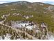 Aerial view of wooded lot and homes in a mountain community during winter at 9239 Black Mountain Dr, Conifer, CO 80433