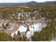 Aerial view showcasing the winding driveway to the house on snow-covered acreage in a wooded location at 9239 Black Mountain Dr, Conifer, CO 80433