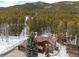 Aerial view of a beautiful wooded lot with a large home, garage and spacious yard at 9239 Black Mountain Dr, Conifer, CO 80433