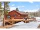 Spacious wooden deck offering a relaxing outdoor space with wood piles ready for the fireplace and views of the surrounding landscape at 9239 Black Mountain Dr, Conifer, CO 80433