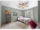 Bedroom with floral bedding, ceiling fan, and shelving beside a large window at 9239 Black Mountain Dr, Conifer, CO 80433